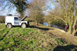 Landrover winching timber on to top of the bank